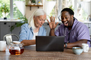 An elderly person and a care assistant discussing with loved ones